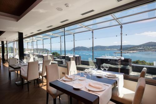 a restaurant with a view of the water at Hotel Thalasso Cantabrico Las Sirenas 4 Superior in Viveiro