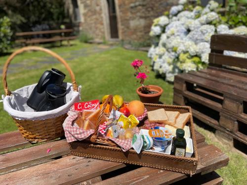 uma mesa de piquenique com uma cesta de comida e bebidas em Casas do Campo em Monfero