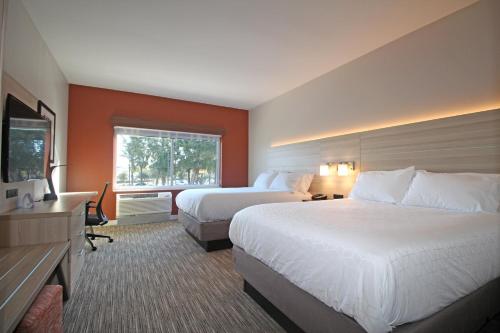 a hotel room with two beds and a television at Holiday Inn Express & Suites Ocala by IHG in Ocala