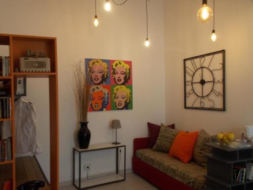 a living room with a couch and a clock on the wall at Ninarella Napoli in Naples