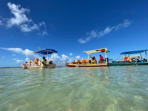two boats with people on them in the water at Chalé Palhano Beach in São Miguel dos Milagres