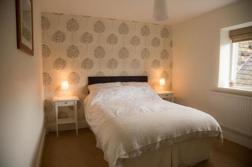 um quarto com uma cama e duas mesas de cabeceira com candeeiros em Millie's Bed & Breakfast em Hayfield