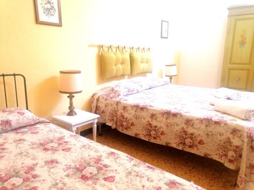 a bedroom with two beds and a lamp at Casa di Osio in Siena