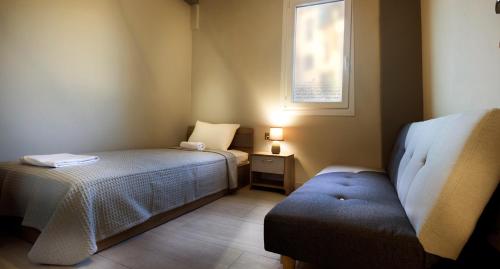 a small bedroom with a bed and a window at Haus Viktoria 3 in Limenas