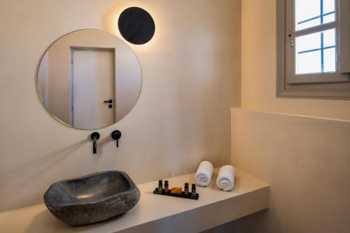 a bathroom with a sink and a mirror at Azanti Suites - Adults Only in Megalochori