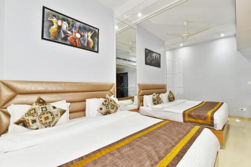 two beds in a room with white walls at Hotel Vacation Inn in Amritsar