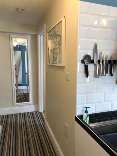 a kitchen with a counter and a sink and a mirror at Little Treasure and Gem with private 2 person Hot Tub and up to 25 percent ferry saving in Shanklin