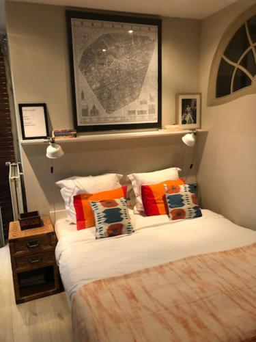 1 dormitorio con 1 cama con almohadas coloridas en Studio Rempart, en Bruselas