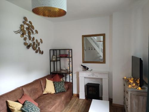 a living room with a couch and a fireplace at Logies l'Epicerie de Durbuy appartement in Durbuy