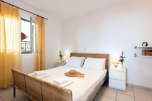 een slaapkamer met een bed met een hoed erop bij Corfu Amboti Apt in Glyfada