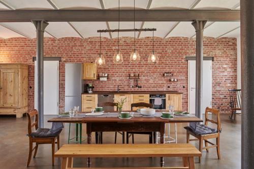 a dining room with a table and a brick wall at re~barn - Modern Country Stay in Essel