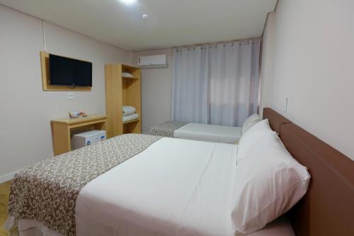 a hotel room with a bed and a television at Fênix Hotel Bom Retiro in Sao Paulo