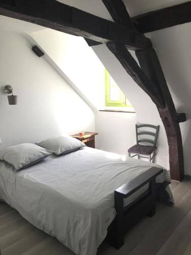 une chambre avec un grand lit et une chaise dans l'établissement Gîte 