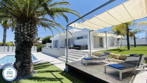 a patio with a palm tree and a house at Moderna by Check-in Portugal in Quarteira