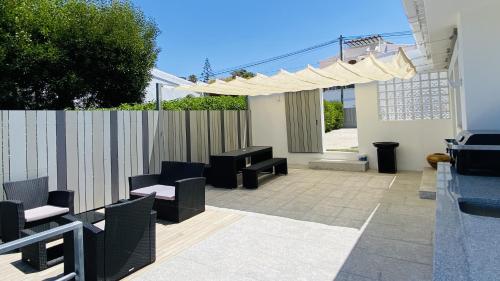 a patio with chairs and tables and a fence at Moderna by Check-in Portugal in Quarteira