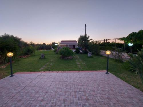 a brick walkway with two lights in a yard at VILLA L&M in Floridia
