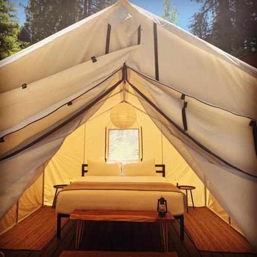 a bed in a canvas tent with a window at Highlands Resort - Adults Only in Guerneville