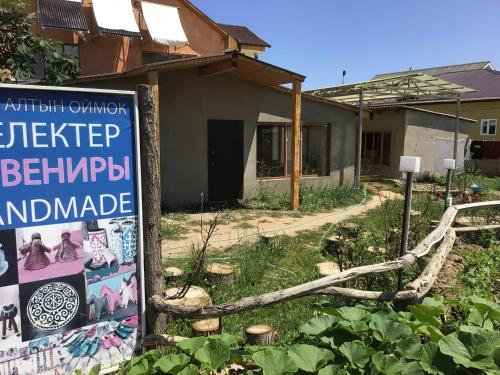a sign in front of a house at Guest House Altyn Oimok in Bokonbayevo