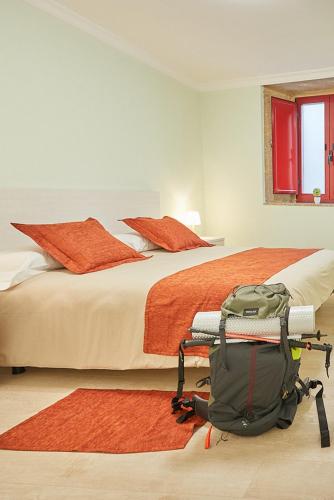 a bedroom with a bed with a backpack on the floor at A Casa Antiga do Monte Apartamentos Turísticos - Lestrove in Padrón
