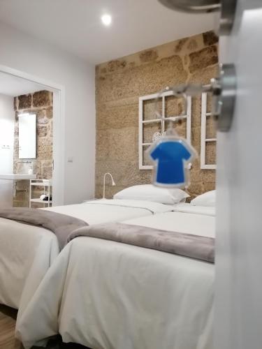 a room with four beds and a blue chair at BIKEINN in Vouzela