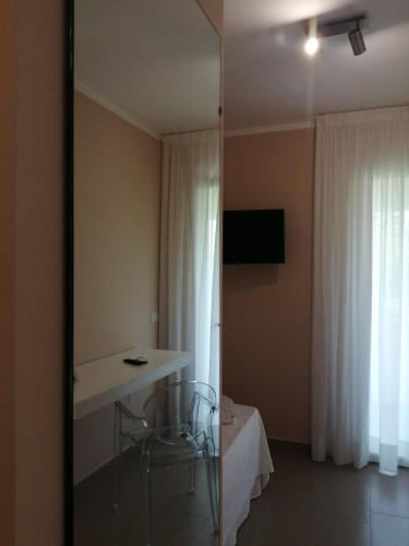 a room with a mirror and a table and a bed at Villa Laura Residence Hotel Apartments & Studios in Ascea