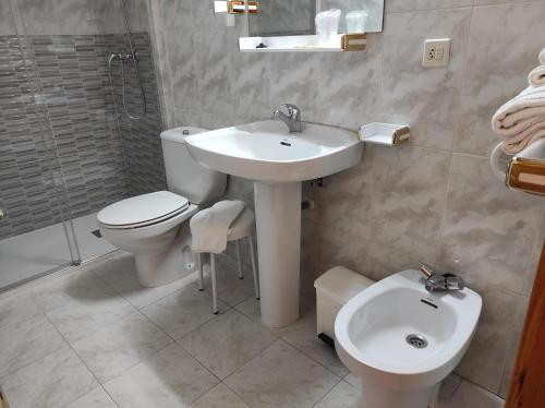 uma casa de banho com um lavatório, um WC e um lavatório. em Hotel Gavin em Gavín