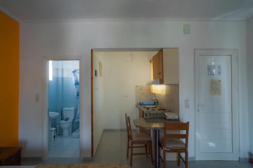 a kitchen and dining room with a table and chairs at Marmaron Rooms in Agiokampos