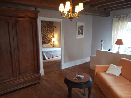 a living room with a couch and a bed at Le CLOS BOURBON in Ferrières-sur-Sichon