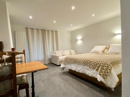 1 dormitorio con cama, mesa y sofá en STUDIO CONFORT & DETENTE en Chesières