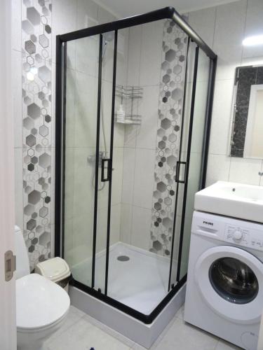 a bathroom with a shower and a washing machine at Apart Gagarina 7 in Kropyvnytskyi