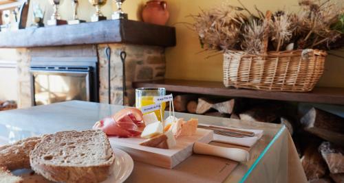 una mesa con un plato de pan y un sándwich en Hotel Casa Cachón, en Tol