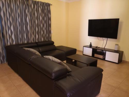 een woonkamer met een bank en een flatscreen-tv bij Villa Arade Ferragudo in Ferragudo