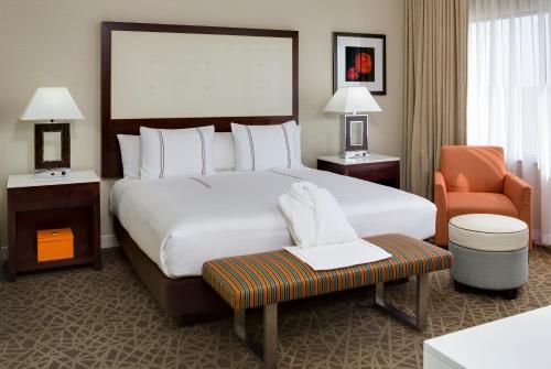 a hotel room with a bed, desk, chair, and lamp at Hyatt Regency Suites Atlanta Northwest in Atlanta