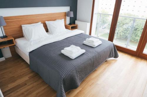 een slaapkamer met een bed met twee handdoeken erop bij Grey Apartment Kołowa in Krakau