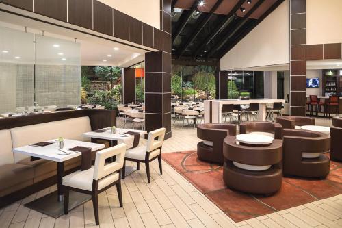 un restaurant avec des tables et des chaises ainsi qu'un bar dans l'établissement Hyatt Regency Suites Atlanta Northwest, à Atlanta