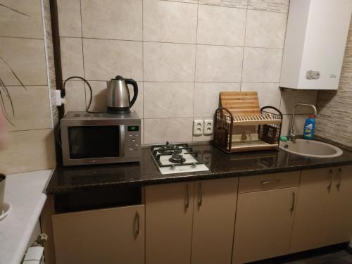 a kitchen with a microwave and a sink at Apart Perspektivna in Kropyvnytskyi