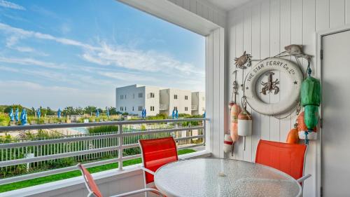 a balcony with a table and chairs and a clock at The Hermitage at Napeague in Amagansett