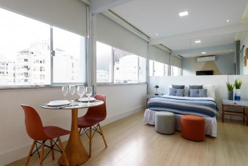 1 dormitorio con 1 cama, mesa y sillas en Vista da praia de Copacabana - NSC1006 Z3, en Río de Janeiro