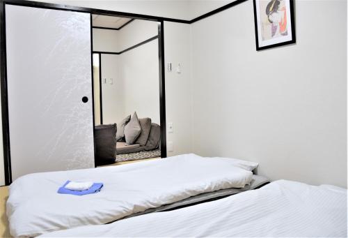 1 dormitorio con espejo y 2 camas en Kamiyama Mansion - Vacation STAY 11596, en Osaka