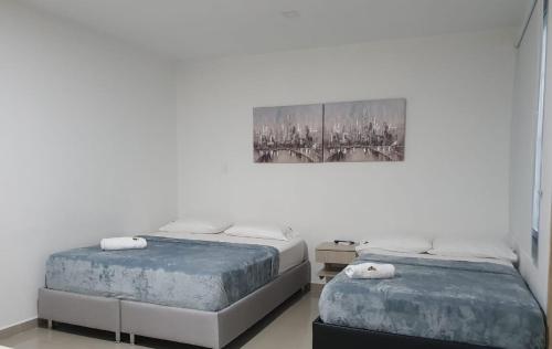 La PazにあるHOTEL SAN PEDROのベッドルーム1室(ベッド2台付)が備わります。壁には絵画が飾られています。