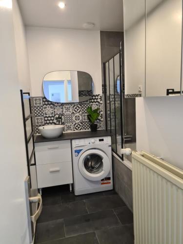 a laundry room with a washing machine and a mirror at Vierzon superbe appartement in Vierzon