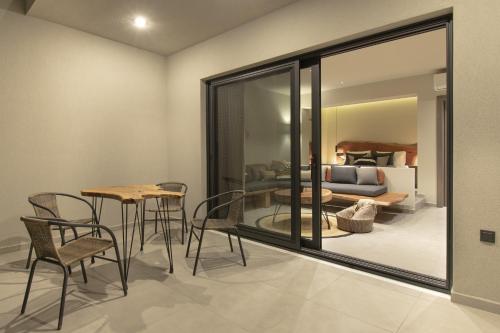 a dining room with a table and chairs and a couch at MOLA PAPAYA STUDIOS in Mola Kalyva