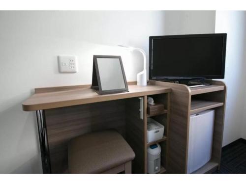 a computer desk with a monitor and a computer monitor at R&B Hotel Shin Osaka Kitaguchi - Vacation STAY 40554v in Osaka