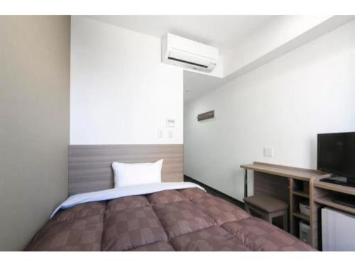 a bedroom with a bed and a desk and a television at R&B Hotel Shin Osaka Kitaguchi - Vacation STAY 40554v in Osaka