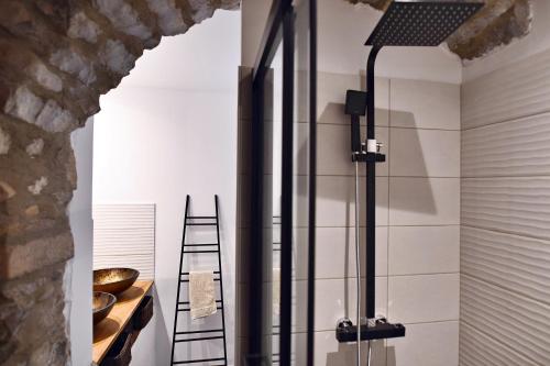 a glass shower in a bathroom with a ladder at Le Bruit de l'Eau (Chambre La Suite) in Labeaume