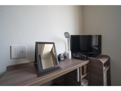 a mirror and a television on a wooden desk at R&B Hotel Hakata Ekimae 2 - Vacation STAY 40725v in Fukuoka