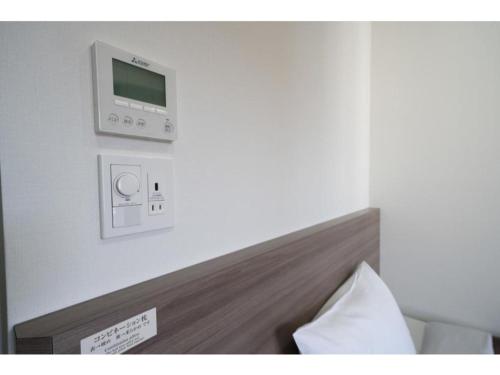 een kamer met een bed en een monitor aan de muur bij R&B Hotel Hakata Ekimae 2 - Vacation STAY 40725v in Fukuoka