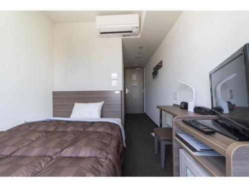 a hotel room with a bed and a desk with a television at R&B Hotel Hakata Ekimae 2 - Vacation STAY 40725v in Fukuoka