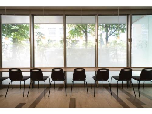 a group of chairs sitting in a room with windows at R&B Hotel Hakata Ekimae 2 - Vacation STAY 40725v in Fukuoka