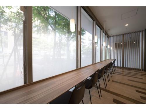 a long table with chairs in a room with windows at R&B Hotel Hakata Ekimae 2 - Vacation STAY 40725v in Fukuoka